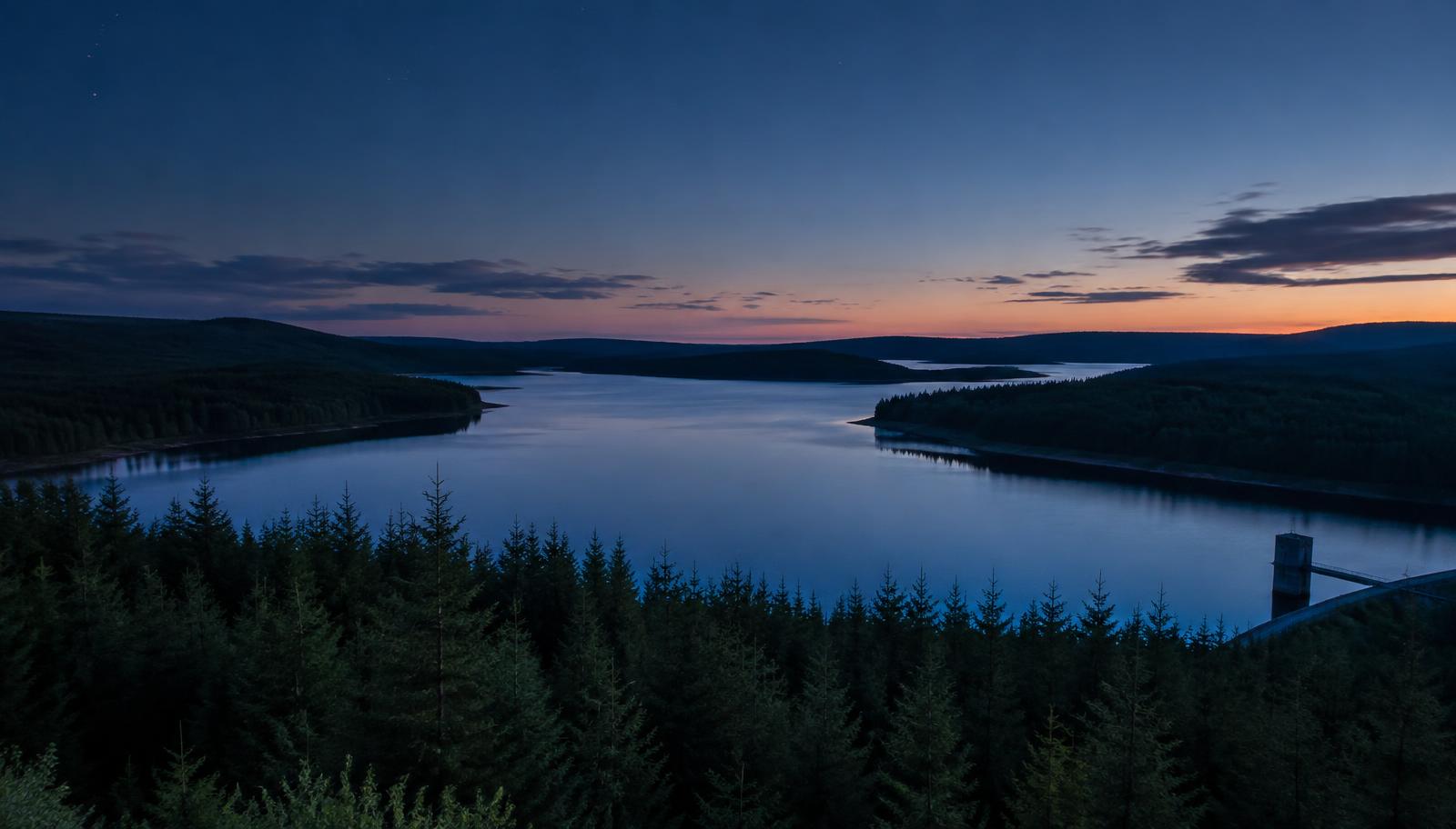 Kielder Water reservoir surrounded by forest at dusk